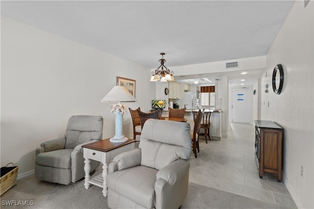 living area with an inviting chandelier and light tile patterned flooring