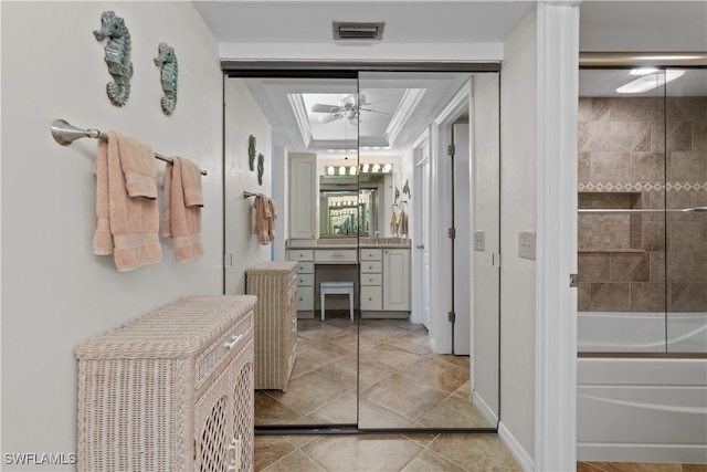 bathroom with tile patterned flooring, ceiling fan, vanity, crown molding, and tiled shower / bath combo