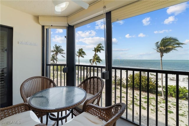 7500 Estero Blvd Unit 203, Fort Myers Beach, FL 33931 - balcony featuring view of water and beach, a ceiling fan, and a sunroom