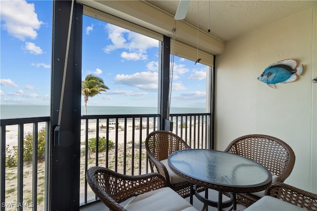 sunroom / solarium with a water view and a view of the beach