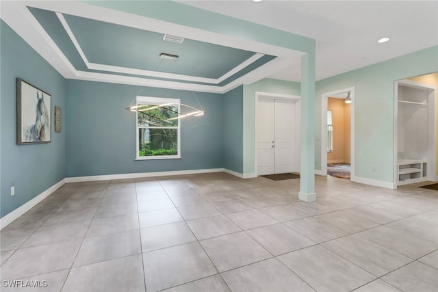 unfurnished bedroom with a notable chandelier, ensuite bath, light tile patterned floors, and a tray ceiling