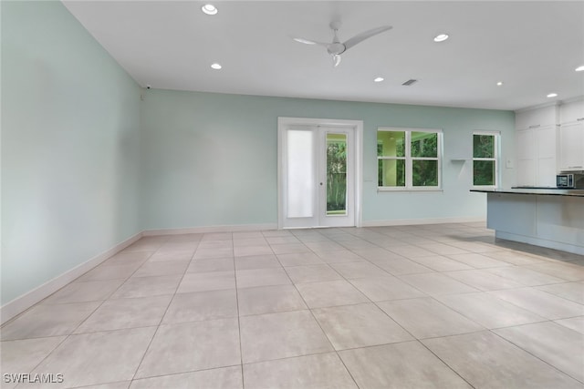 unfurnished living room with ceiling fan and light tile patterned flooring