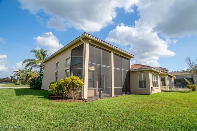 view of property exterior featuring a yard and a sunroom