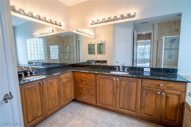 bathroom featuring a shower with door, tile patterned flooring, and vanity