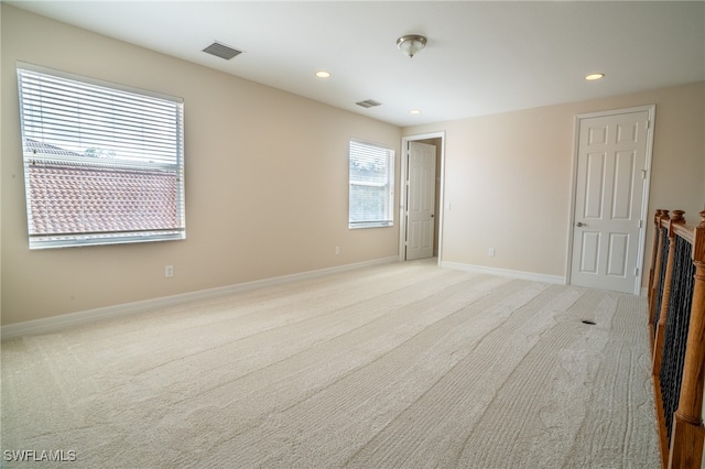 unfurnished room featuring light carpet