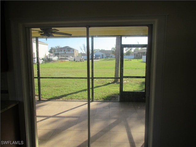 doorway to outside featuring ceiling fan and tile patterned flooring