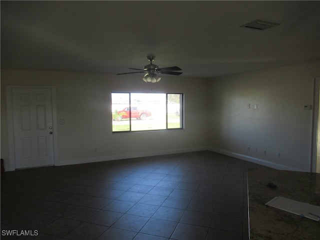 tiled empty room featuring ceiling fan