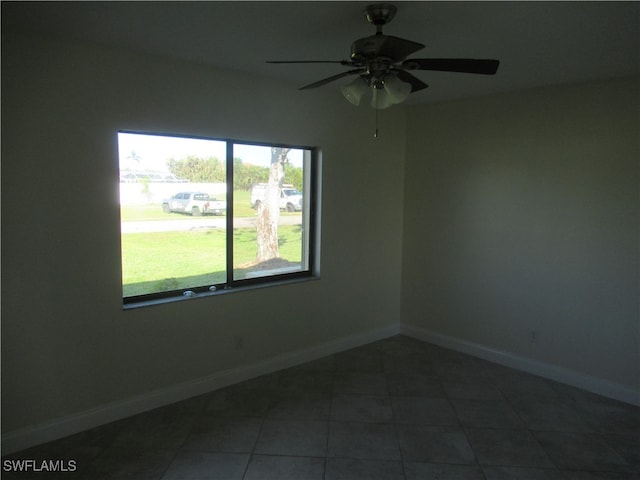 tiled spare room with ceiling fan