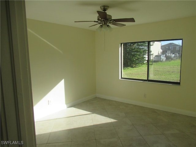 tiled empty room featuring ceiling fan