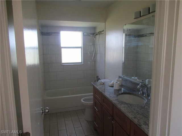 full bathroom with vanity, tiled shower / bath, and toilet