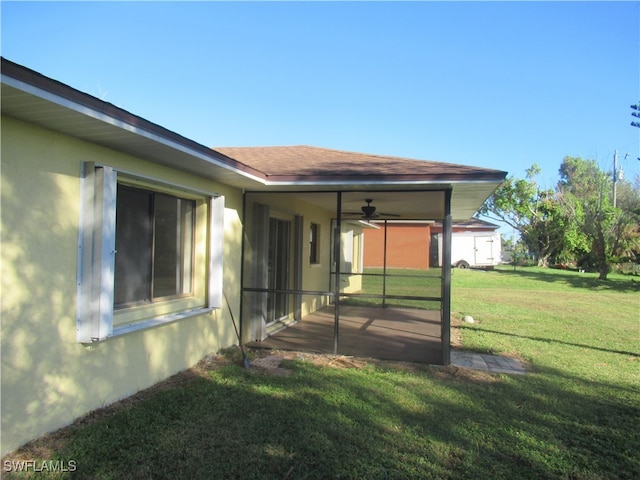 back of house featuring a yard and ceiling fan