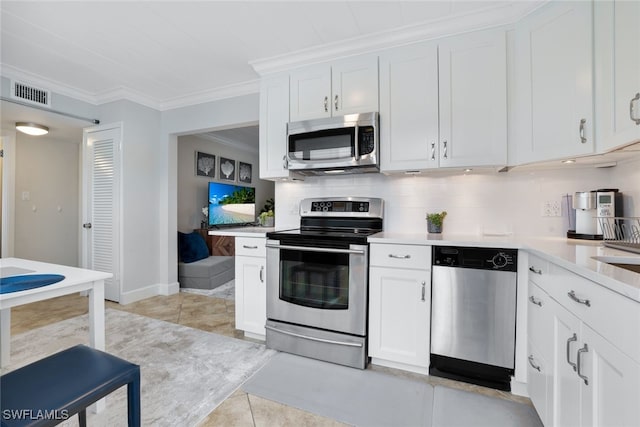 kitchen with appliances with stainless steel finishes, crown molding, white cabinets, and light tile patterned floors