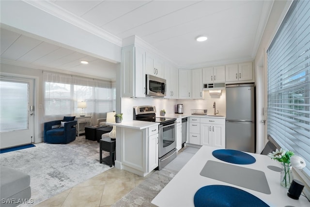 kitchen with white cabinetry, crown molding, stainless steel appliances, and light tile patterned floors