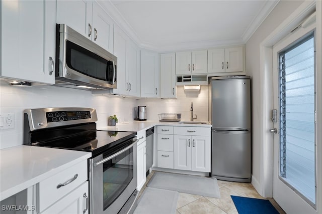 kitchen featuring sink, appliances with stainless steel finishes, white cabinetry, and light tile patterned flooring