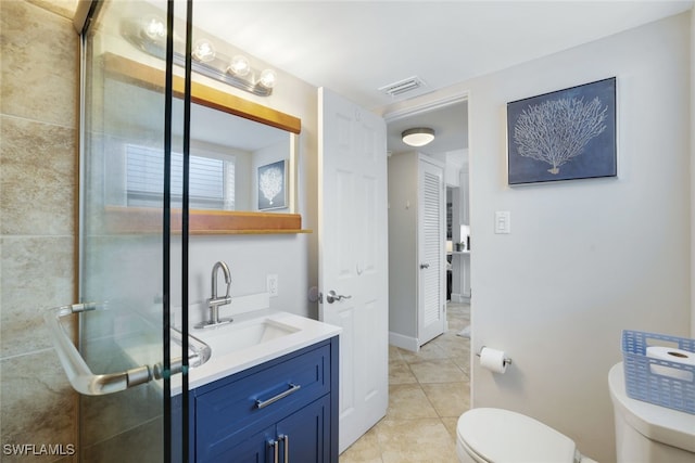 bathroom with a shower with door, vanity, toilet, and tile patterned flooring