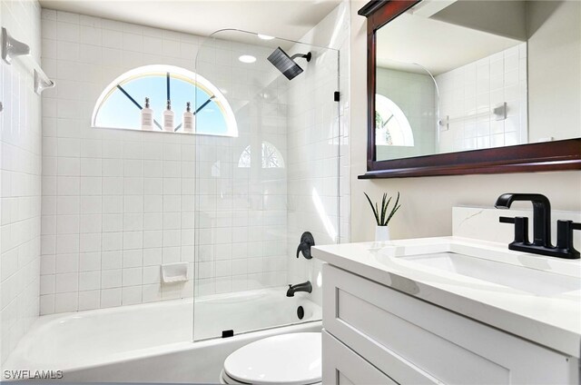 full bathroom featuring toilet, tiled shower / bath combo, and vanity