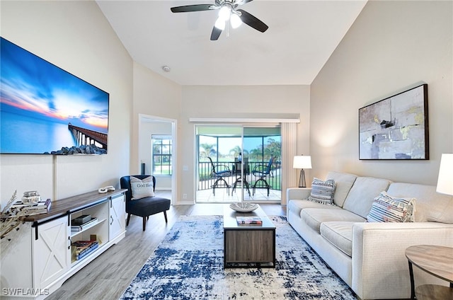 living area featuring light wood-style flooring, baseboards, and ceiling fan