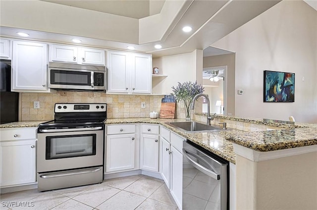 28080 Cavendish Ct Unit 2007, Bonita Springs, FL 34135 - kitchen featuring stainless steel appliances, open shelves, a peninsula, tasteful backsplash, and white cabinets