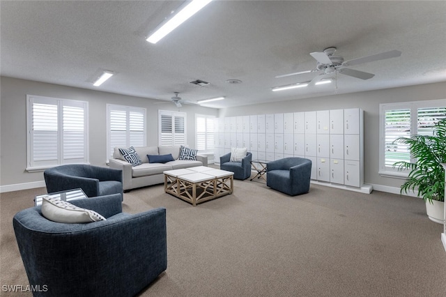 carpeted living room with a textured ceiling and ceiling fan