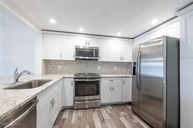 kitchen featuring appliances with stainless steel finishes, white cabinetry, and sink