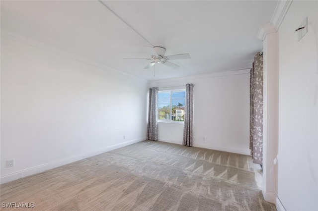 carpeted spare room featuring crown molding and ceiling fan