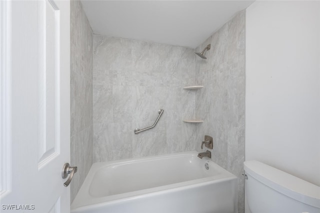 bathroom with tiled shower / bath combo and toilet