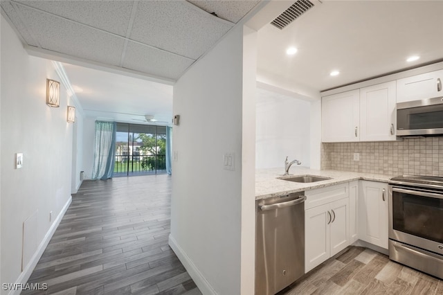 kitchen featuring appliances with stainless steel finishes, light hardwood / wood-style floors, white cabinetry, and sink