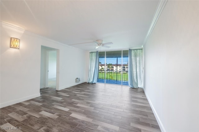 empty room featuring hardwood / wood-style floors, ceiling fan, floor to ceiling windows, and ornamental molding