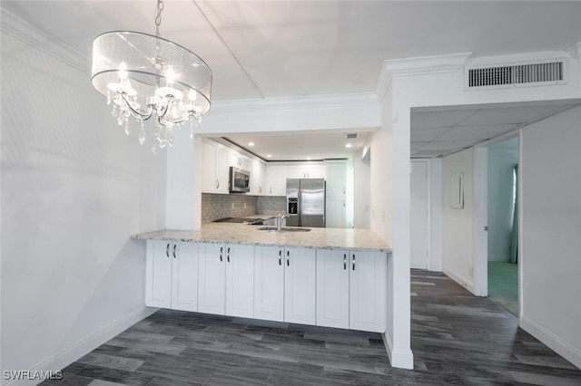 kitchen with hanging light fixtures, light stone counters, a notable chandelier, white cabinets, and appliances with stainless steel finishes