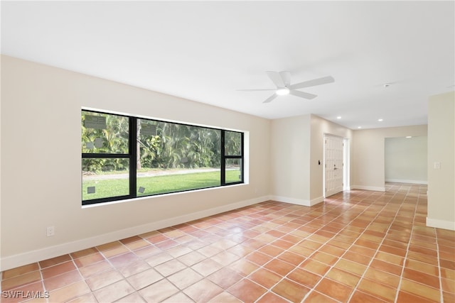 tiled spare room featuring ceiling fan