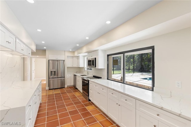8531 Yorkshire Ln, Fort Myers, FL 33919 - kitchen with stainless steel appliances, a sink, white cabinets, and recessed lighting