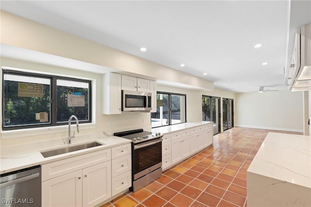 8531 Yorkshire Ln, Fort Myers, FL 33919 - kitchen featuring appliances with stainless steel finishes, a sink, tile patterned floors, white cabinetry, and recessed lighting