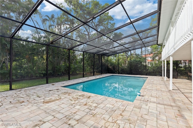 view of pool featuring glass enclosure and a patio area