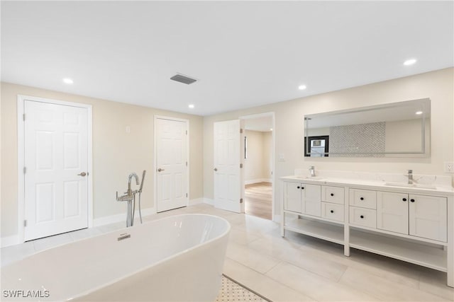 8531 Yorkshire Ln, Fort Myers, FL 33919 - bathroom with double vanity, a soaking tub, recessed lighting, tile patterned floors, and baseboards