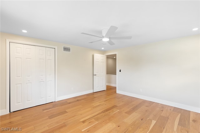 unfurnished bedroom with ceiling fan, light wood-type flooring, and a closet