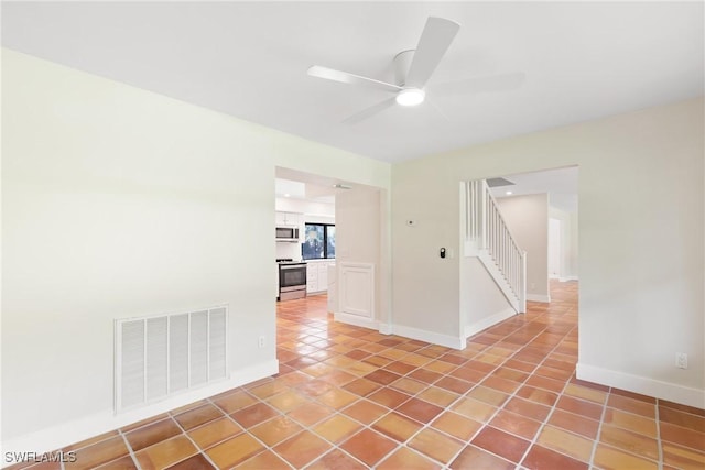 8531 Yorkshire Ln, Fort Myers, FL 33919 - empty room featuring ceiling fan, light tile patterned flooring, and stairway