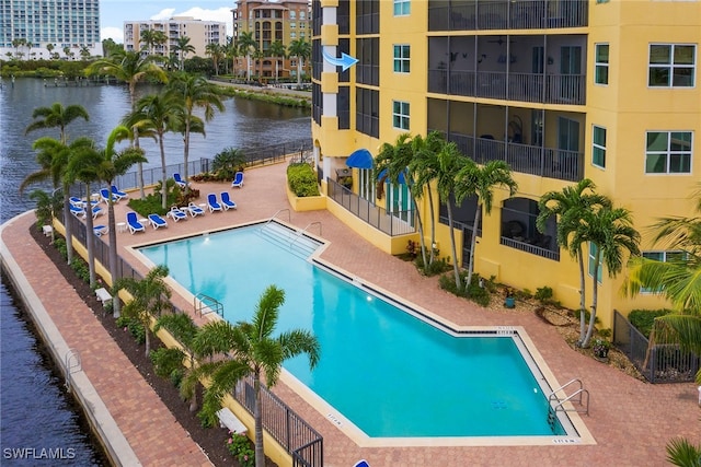 view of swimming pool featuring a patio area and a water view