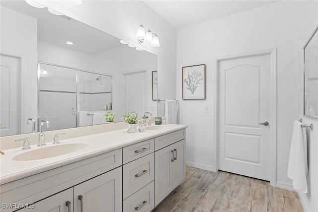 bathroom featuring a shower with door, hardwood / wood-style flooring, and vanity