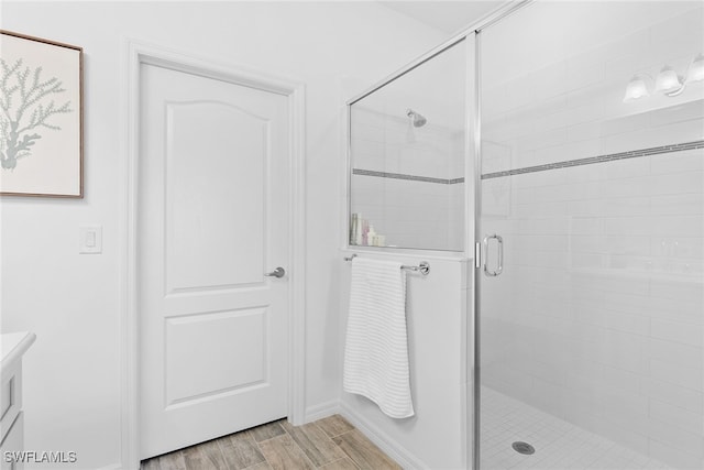 bathroom with hardwood / wood-style flooring and walk in shower