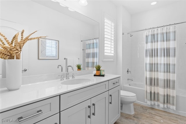 full bathroom featuring vanity, toilet, hardwood / wood-style flooring, and shower / bathtub combination with curtain