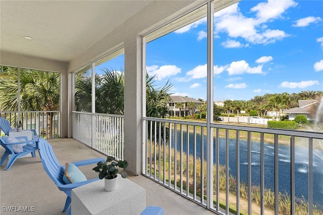 sunroom / solarium featuring a water view