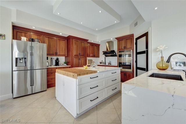 kitchen with appliances with stainless steel finishes, sink, a center island, white cabinetry, and range hood