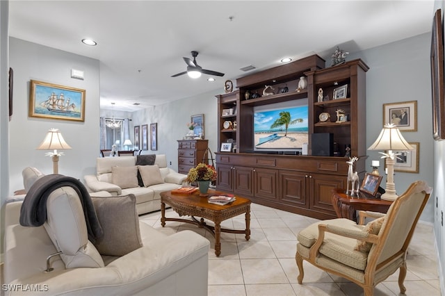 tiled living room with ceiling fan with notable chandelier