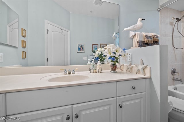 full bathroom featuring vanity, tiled shower / bath combo, and toilet