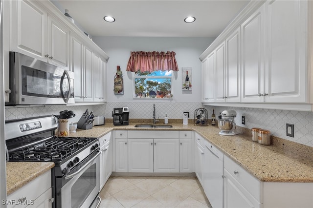 kitchen featuring appliances with stainless steel finishes, white cabinetry, and sink