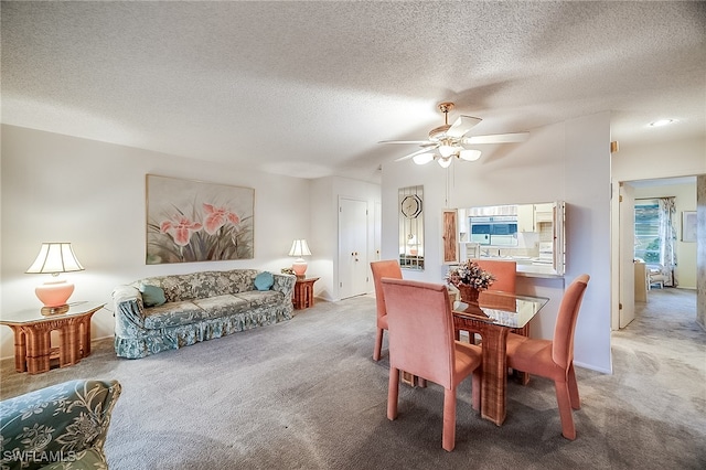 carpeted dining area with ceiling fan and a textured ceiling