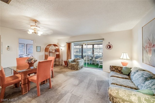 dining room with a textured ceiling, carpet floors, and ceiling fan