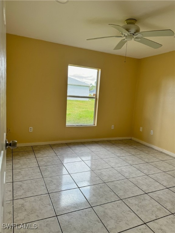 tiled spare room featuring ceiling fan