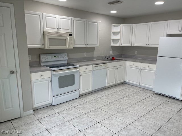 kitchen with white cabinetry, light tile patterned flooring, sink, and white appliances