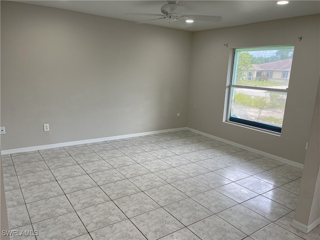 empty room with ceiling fan and light tile patterned floors